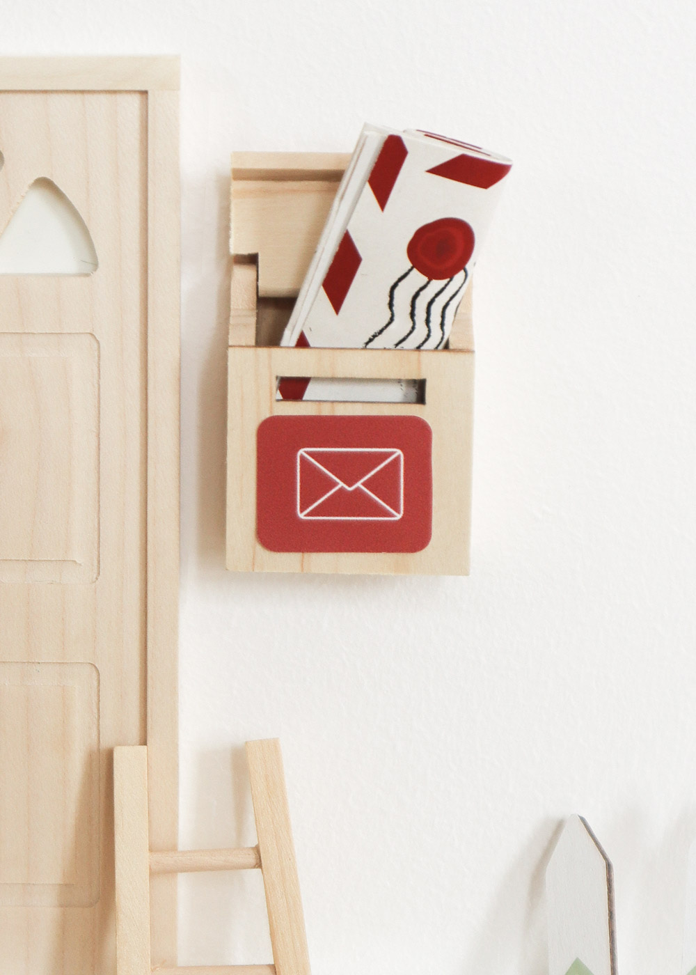Gefüllter Briefkasten vom Weihnachtswichtel neben seiner Wichteltür
