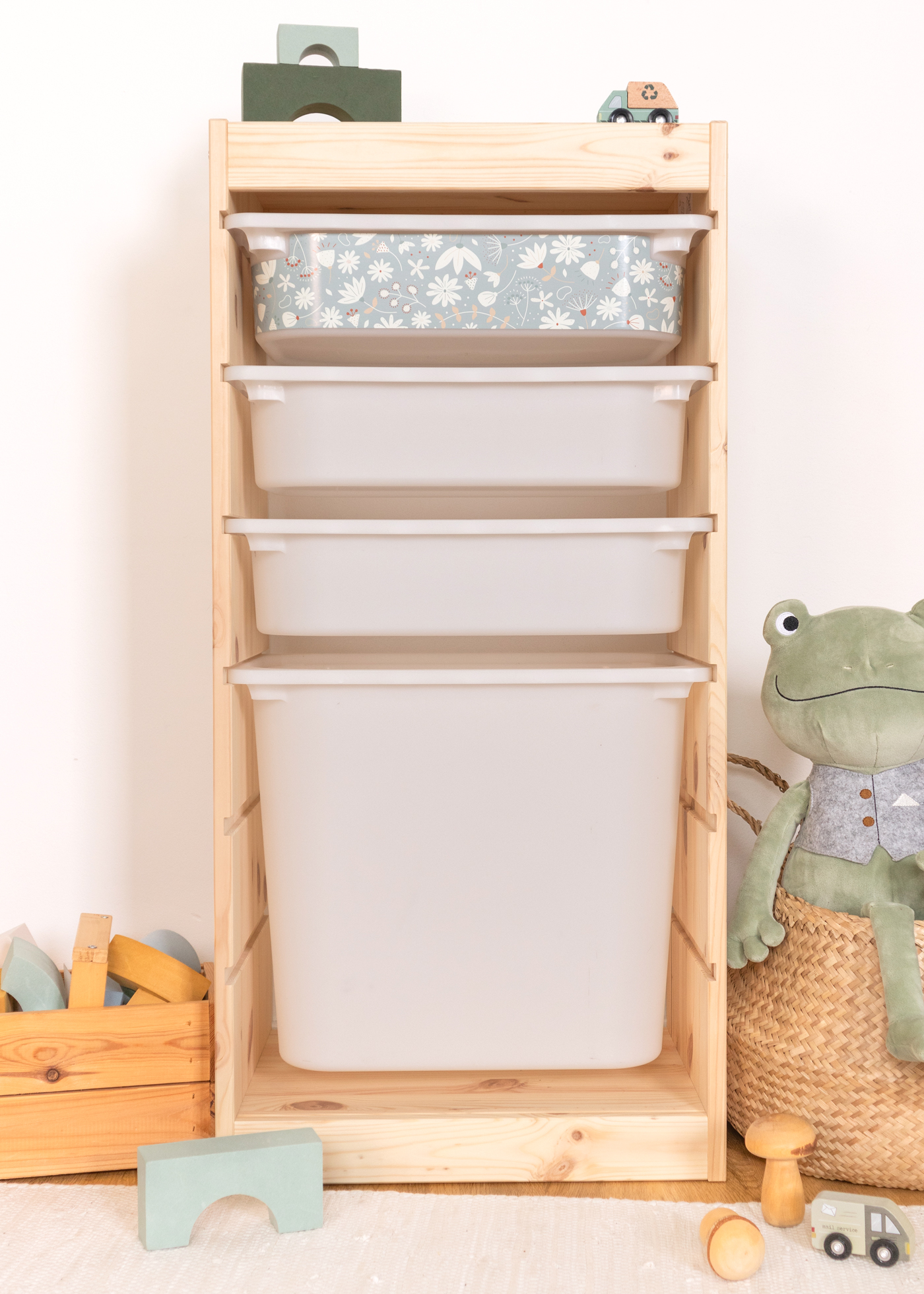 Kinder-Aufbewahrung mit grünem Blumenmuster im TROFAST Regal IKEA TROFAST Regal mit grünem Blumenmuster auf der Aufbewahrungsbox, ideal für das Kinderzimmer.