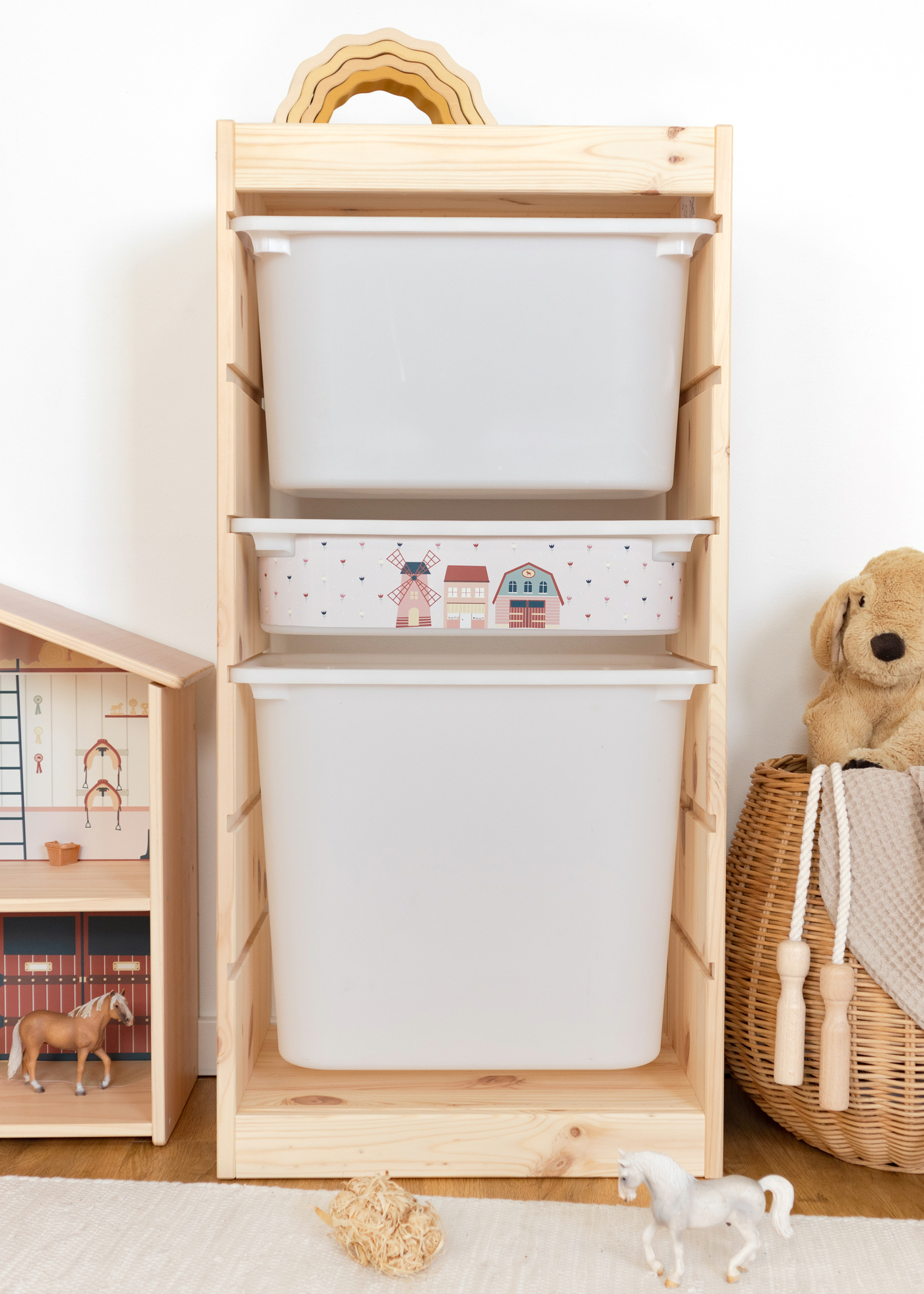 Spielzeugaufbewahrung mit Dorf-Design im IKEA Regal IKEA TROFAST Regal mit rosa Box, dekoriert mit einem Dorf-Motiv für das Kinderzimmer.