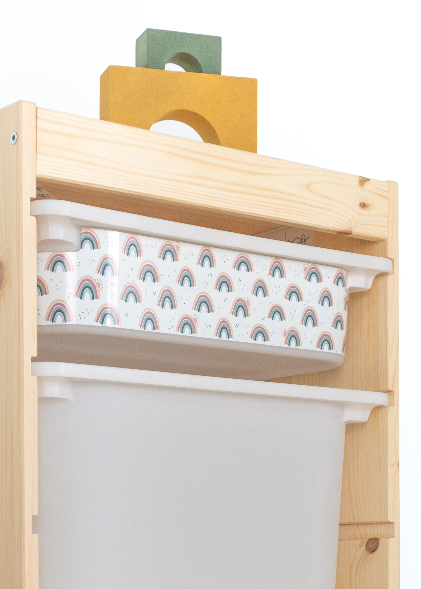 Beige Box mit Regenbogen-Muster im IKEA TROFAST Regal Kindgerechte beige Box im TROFAST Regal, bedruckt mit mehreren bunten Regenbögen.