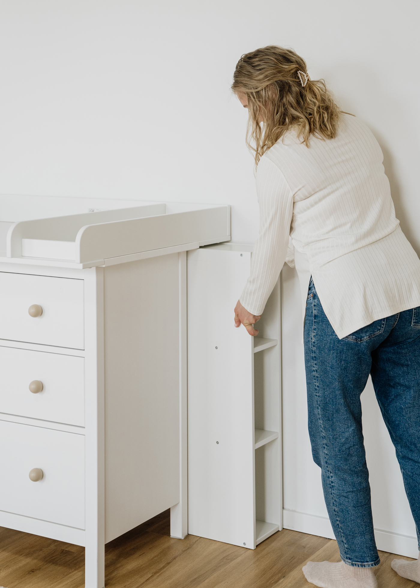 Wickelaufsatz für IKEA HEMNES mit Regal eine Frau schiebt ein weißes Regal hinter die Ikea Hemnes mit Wickelaufsatz