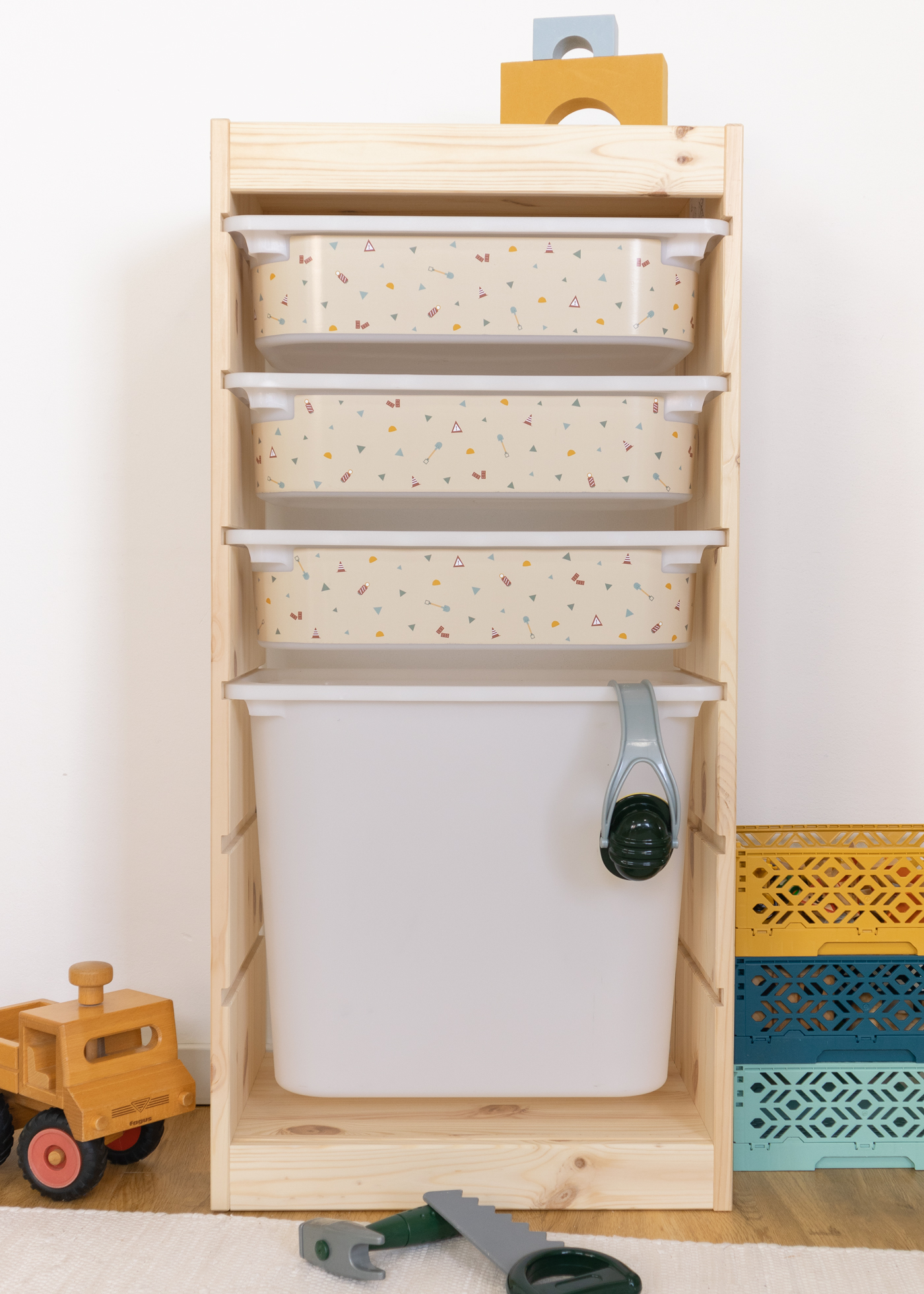 Dekorative Box mit Baustellen-Themen im TROFAST Regalsystem Beige Aufbewahrungsbox im IKEA TROFAST Regal mit Baustellenmotiven von Bagger, Kran und Kipplader.