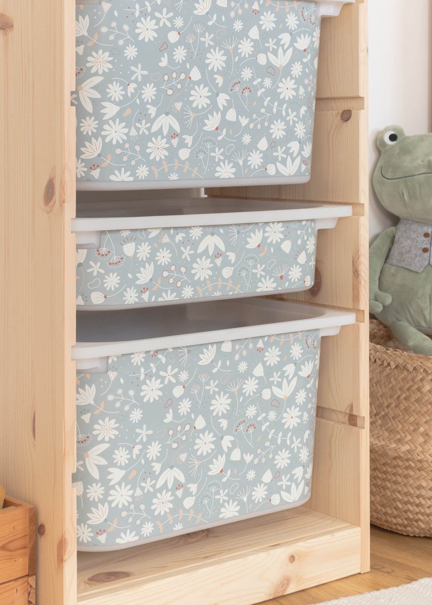 Grünes Blumenmuster auf Aufbewahrungsbox im IKEA Regal Kinderfreundliche Aufbewahrungsbox im IKEA TROFAST Regal mit grünem Blumenmotiv.