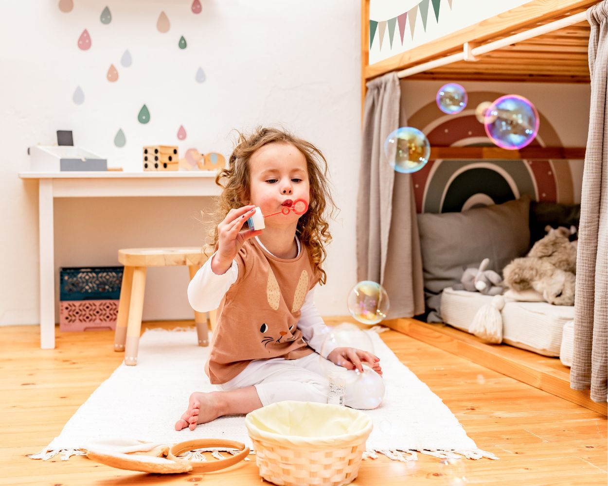 Ein glückliches Mädchen pustet Seifenblasen in ihrem Kinderzimmer