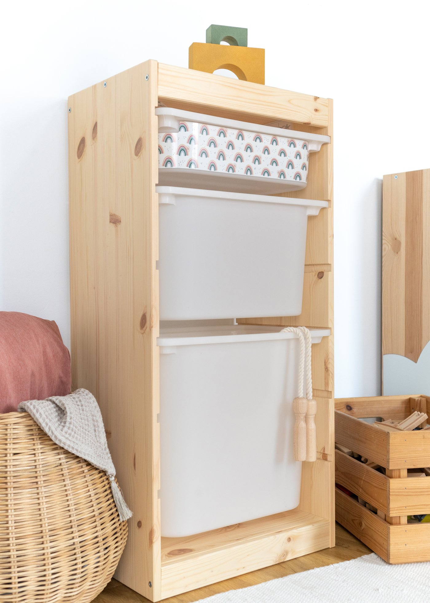 Aufbewahrungsbox mit Regenbogen-Muster im IKEA Regal Kinderfreundliche Box mit einem wiederkehrenden Regenbogen-Motiv im IKEA TROFAST Regal.