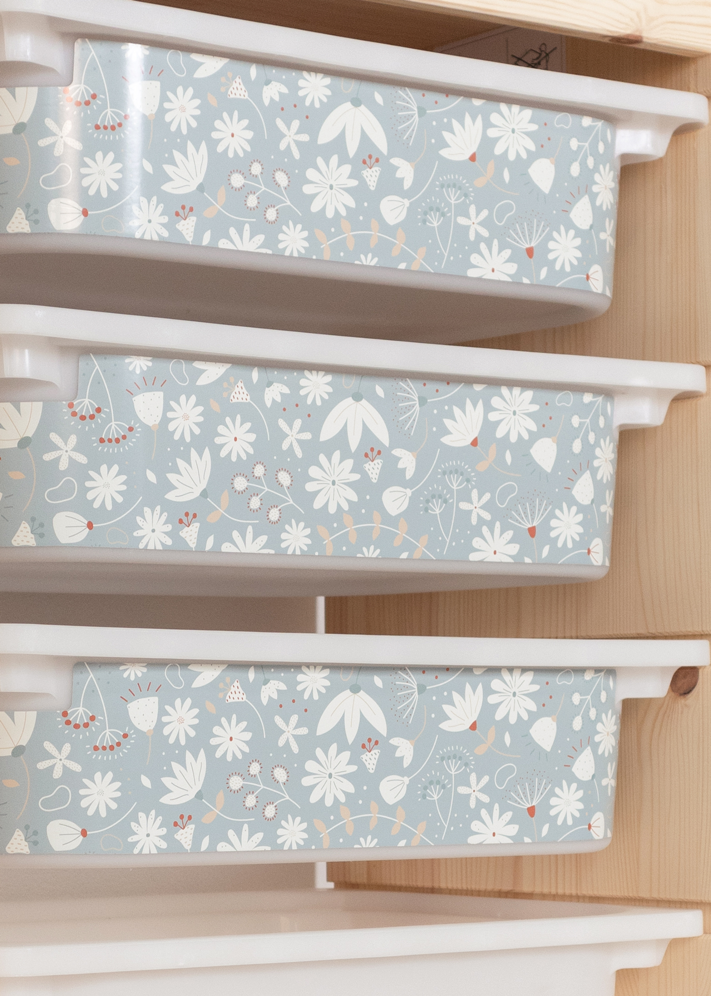 Kinder-Aufbewahrungsbox im TROFAST Regal mit grünem Blumenmuster Aufbewahrungsbox im IKEA TROFAST Regal, verziert mit einem stilvollen grünen Blumenmuster.