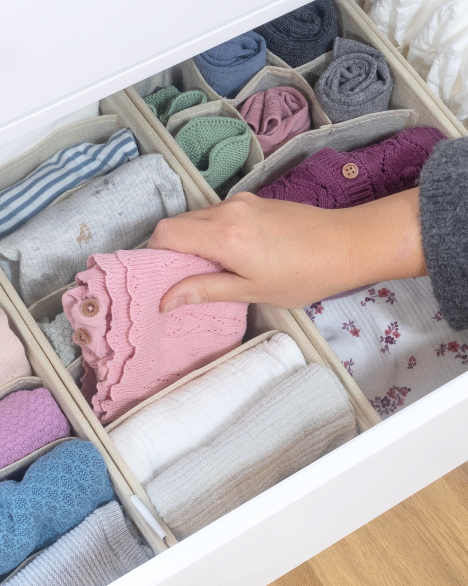 Babybekleidung, Strickpullover, pinkes Cardigan, Schubladenorganisation, weiche Stoffe