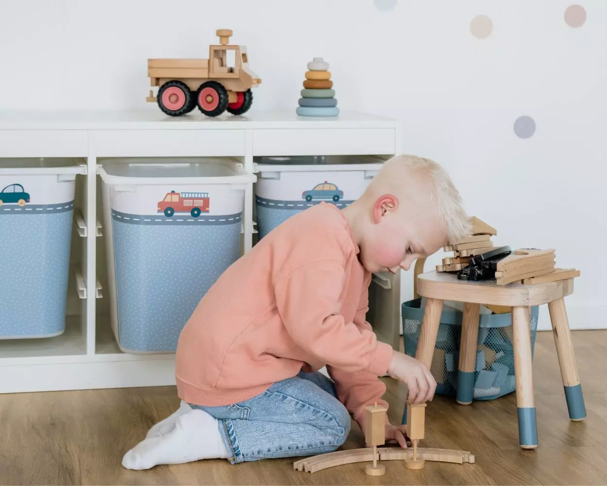 Ein Junge spielt mit Bauklötzen auf dem Boden seines Kinderzimmers